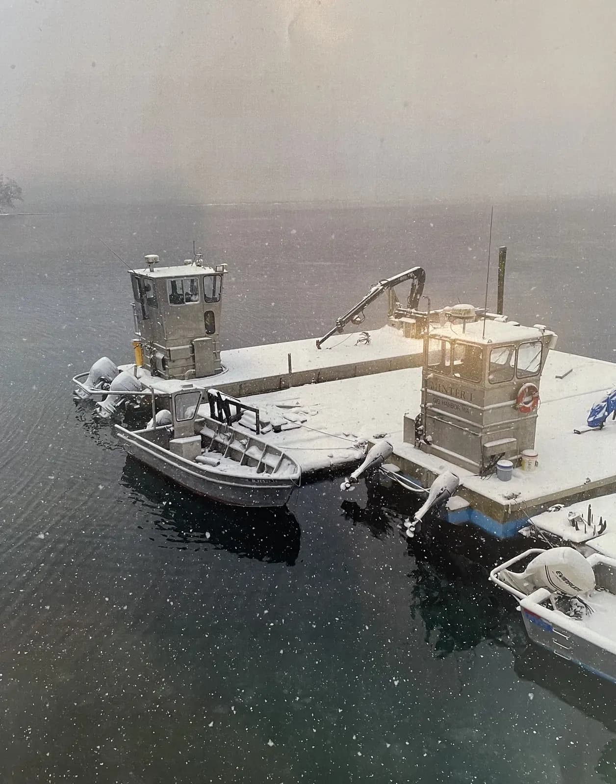 Snow falling on the boats at the dock