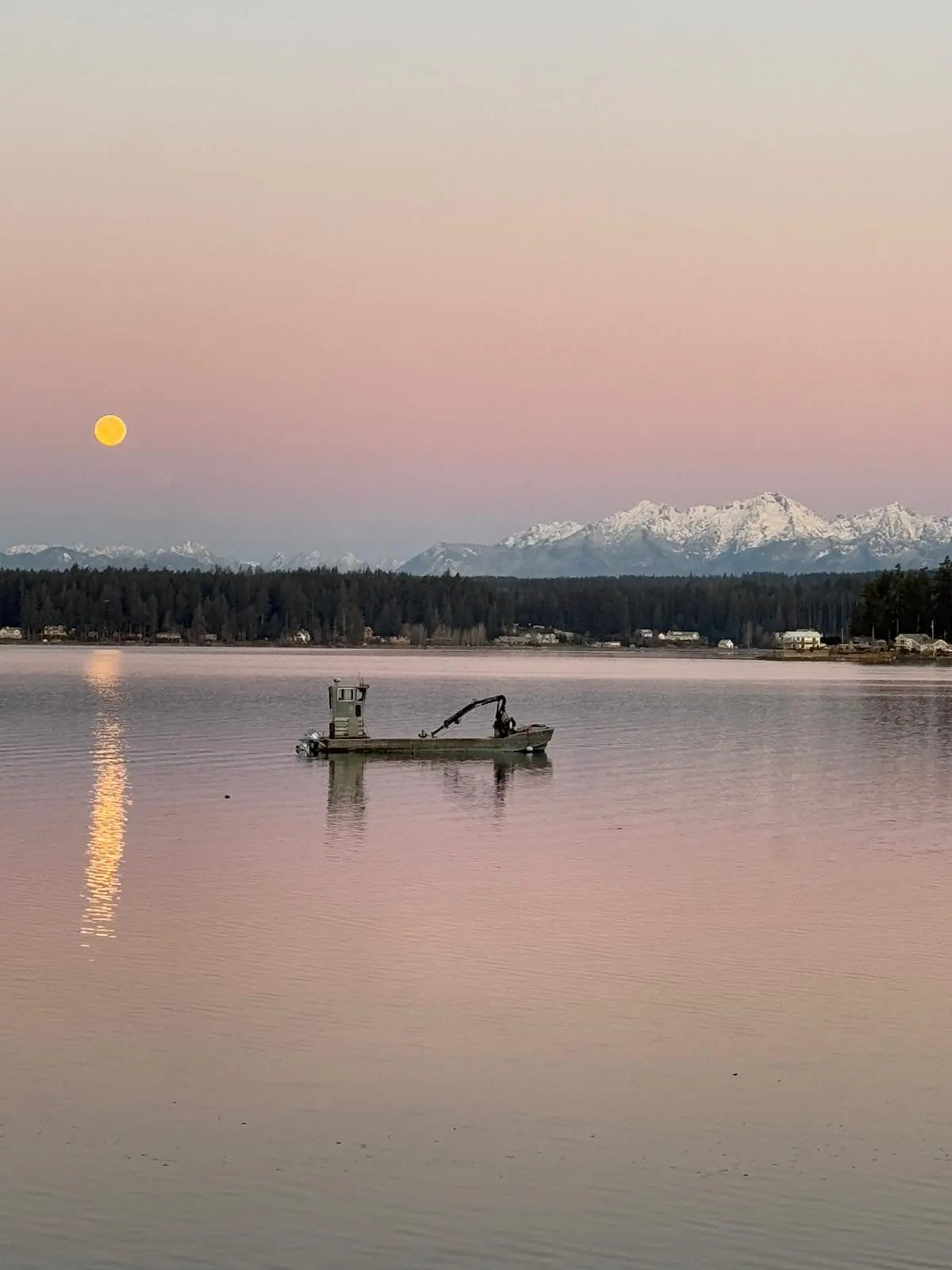 The Olympics at dawn, a boat working below
