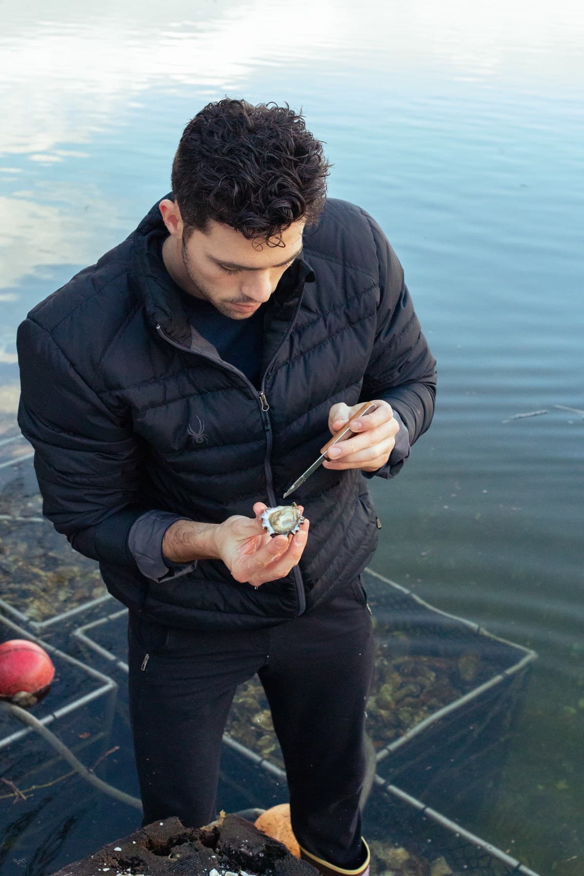 Garrett shucking a Minterbrook oyster on the bay